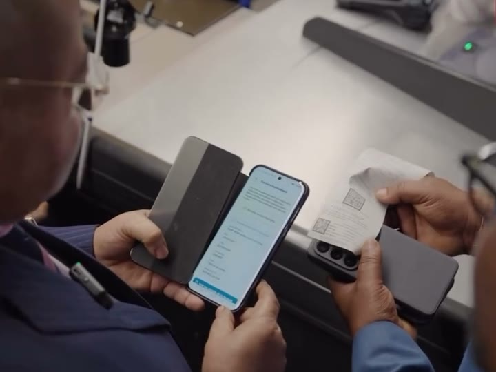 Le directeur général de la DGI vérifie une facture sur un téléphone à une caisse de City Market.